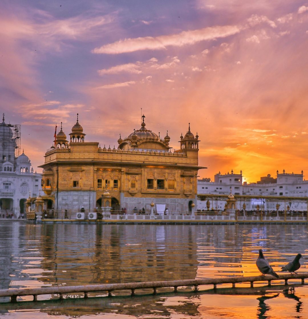 pexels photo 5458388 5458388 Exterior of Sikh gurdwara golden temple with dome located near water against cloudy sky in evening time in city in India